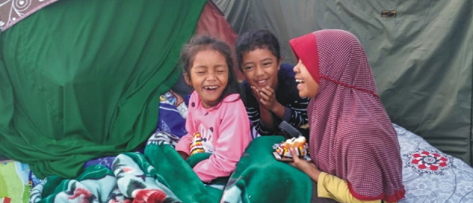 Foto tiga anak kecil yang sedang tertawa