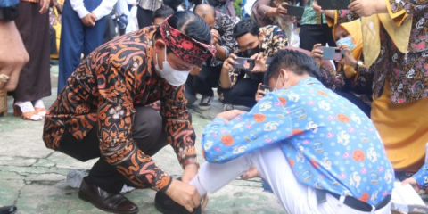 Wakil Wali Kota Bengkulu Dedy Wahyudi saat memeasangkan sepatu kepada siswa SMPN 01 Kota Bengkulu